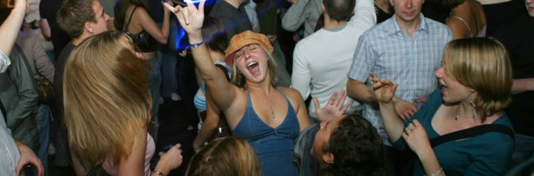 girl with hands in the air on dancefloor