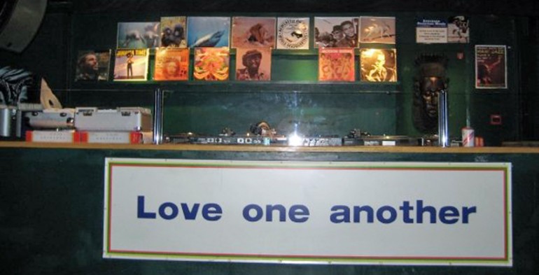 Dj booth with sign saying 'love one another'