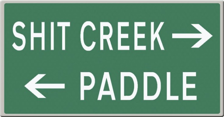 Sign directing 'Shit Creek' to the right and 'Paddle' to the left