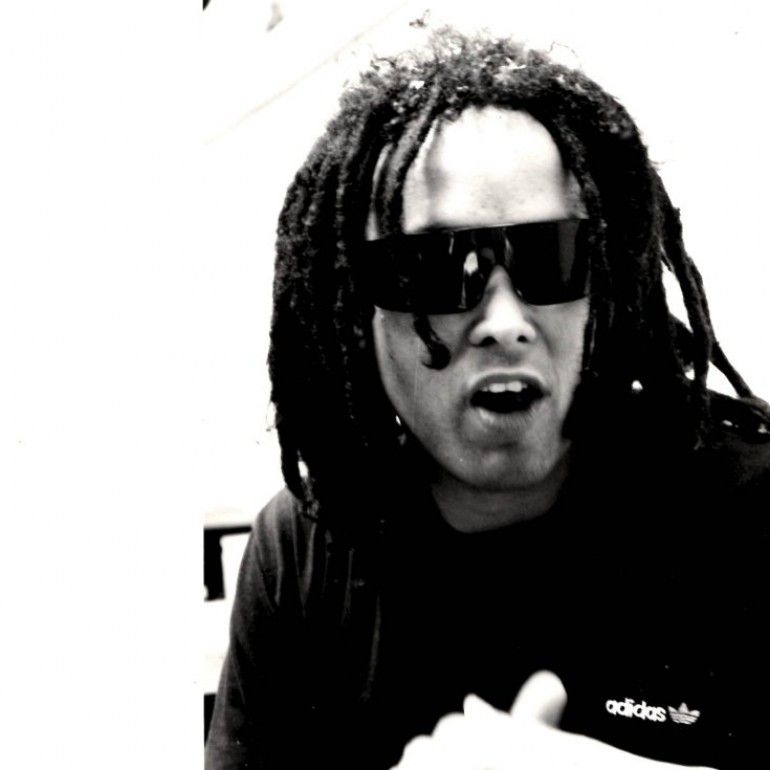 Man with short dreadlocks wearing sunglasses