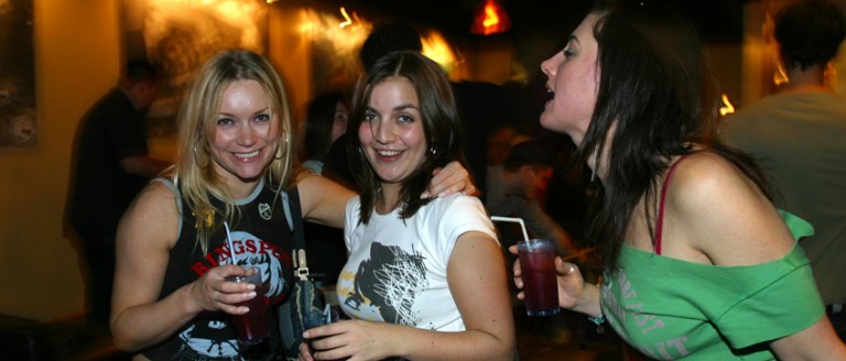 Three girls with drinks smiling